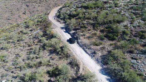 un jeep filmado por un avión no tripulado subiendo por la carretera table mesa