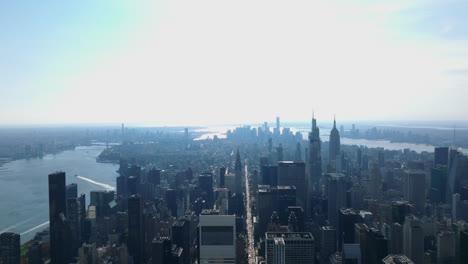 Aerial-panoramic-view-of-city-on-island-surrounded-by-water.-Downtown-skyscrapers-against-bright-sky.-Manhattan,-New-York-City,-USA