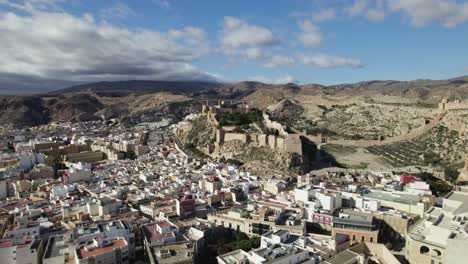 Aerial-view-over-the-cityscape,-towards-the-Muralla-de-Jairán-Castle-in-Almeria,-Spain---circling,-drone-shot