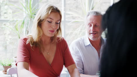 Senior-man-sitting-at-table-talking-with-friends-during-lunch-at-a-restaurant,-close-up