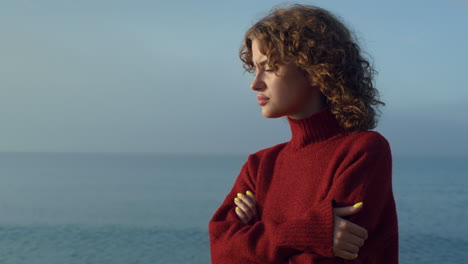 pensive girl standing at seaside. thoughtful woman face with closed eyes