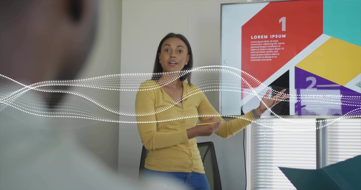 Presentatrice che preme un telecomando, indicando una diapositiva aziendale e evidenziando il pannello rosso 1 con una forma d'onda.