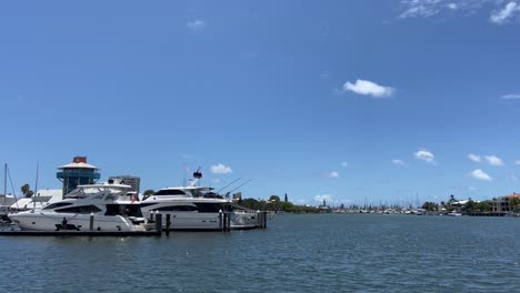 un puerto deportivo tranquilo con elegantes barcos de cruceros blancos, bajo un cielo azul perfecto de verano
