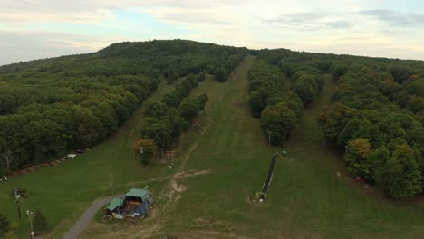 Bird's-eye-view-of-un-used-ski-mountain-in-the-summer-with-lush-forest