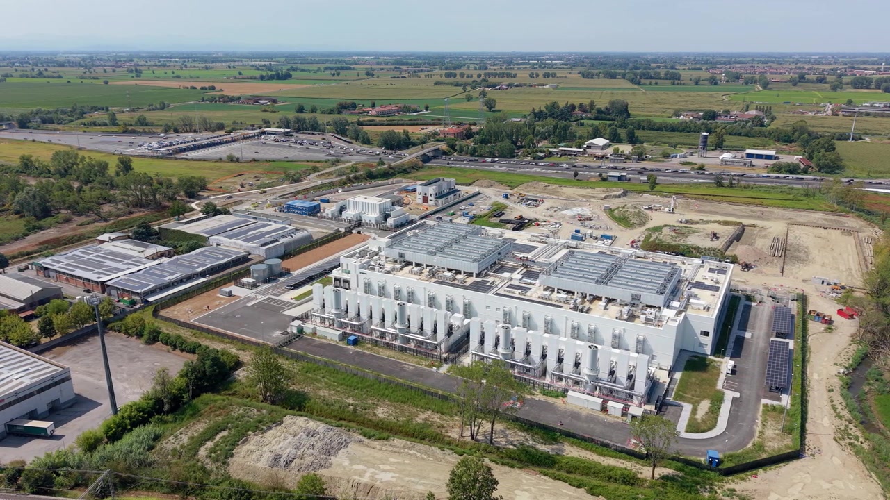 Luftfoto af et moderne datacenter i Melegnano, Italien, der viser avanceret digital infrastruktur og teknologi-bygninger til erhvervsbrug.