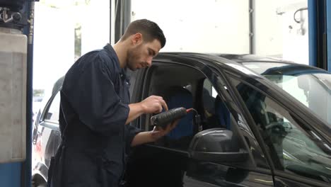 un guapo mecánico revisando un coche