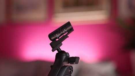 wireless microphone mounted on tripod stick with red bokeh background