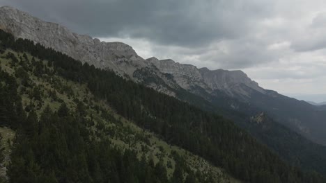 Cool-aerial-view-advancing-over-the-forest-and-next-to-the-cliff-of-the-Cadi-mountain-range-in-La-Cerdanya,-Catalunya