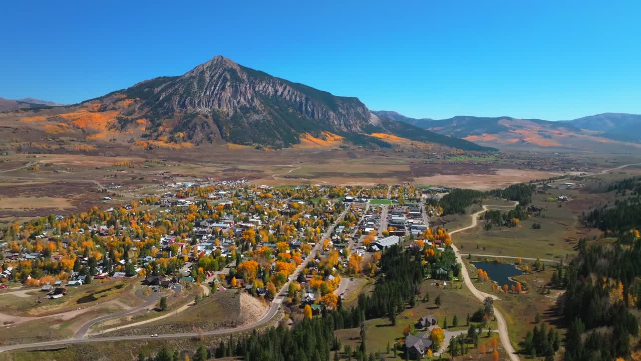 Mount Crested Butte mountain town ski resort Kebler Ohio Pass aerial drone Colorado morning vibrant Aspen Trees fall autumn auburn peak colors Gunnison National forest sunny blue sky circle right