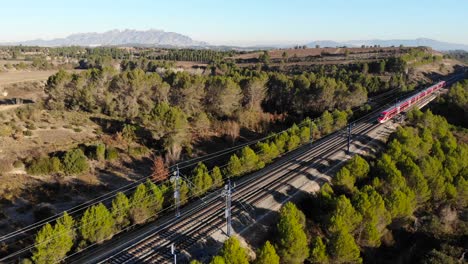 Aerial:-high-speed-red-train-in-Spain,-between-Barcelona-and-Madrid-in-Catalonia