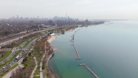 traffic on coastal lakeshore boulevard and gardner expressway. aerial wide shot. downtown toronto skyline in background. silhouette of skyline in distance.