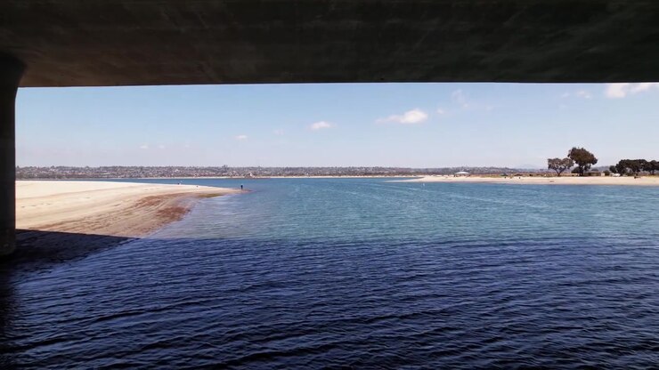 Drone flying under a bridge at Mission Bay Park in San Diego California capturing unique waterfront perspective.