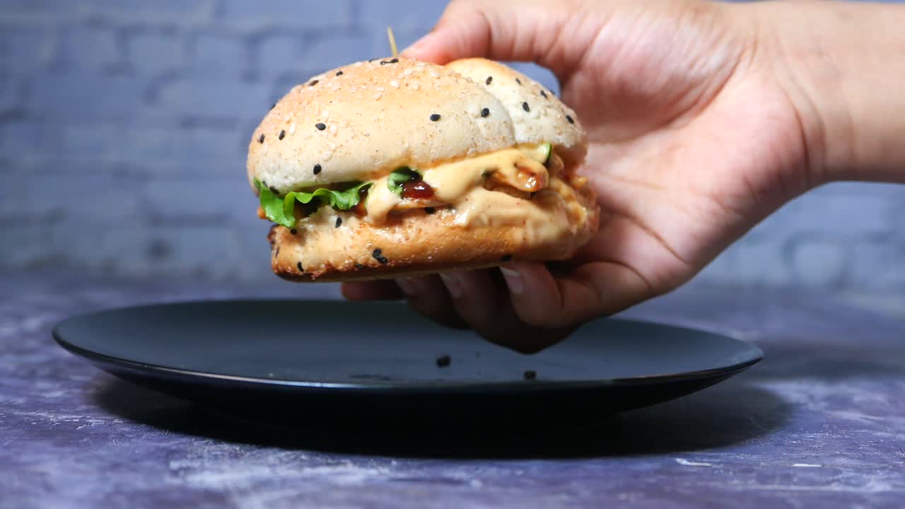 mano con una deliciosa hamburguesa de pollo