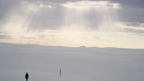 Hermosos-Rayos-De-Luz-Del-Amanecer-En-Arenas-Blancas-Nuevo-México-Con-Excursionista-En-Dunas-De-Arena