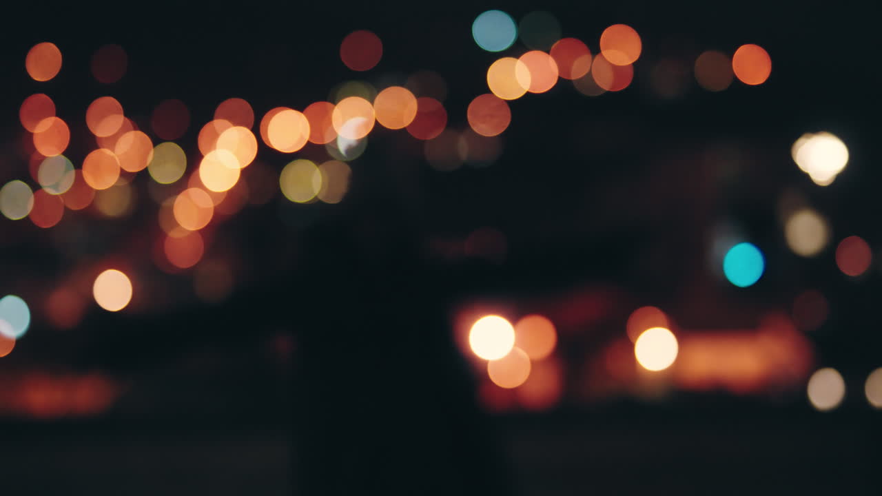 feliz mujer caucásica sosteniendo bengalas bailando en la azotea por la noche celebrando la víspera de año nuevo disfrutando de la celebración navideña