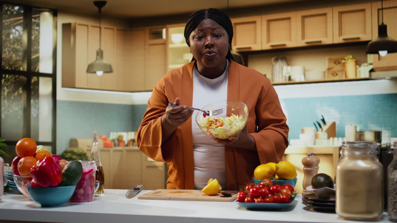 Black food vlogger mixing vegetables for a salad recipe in bowl
