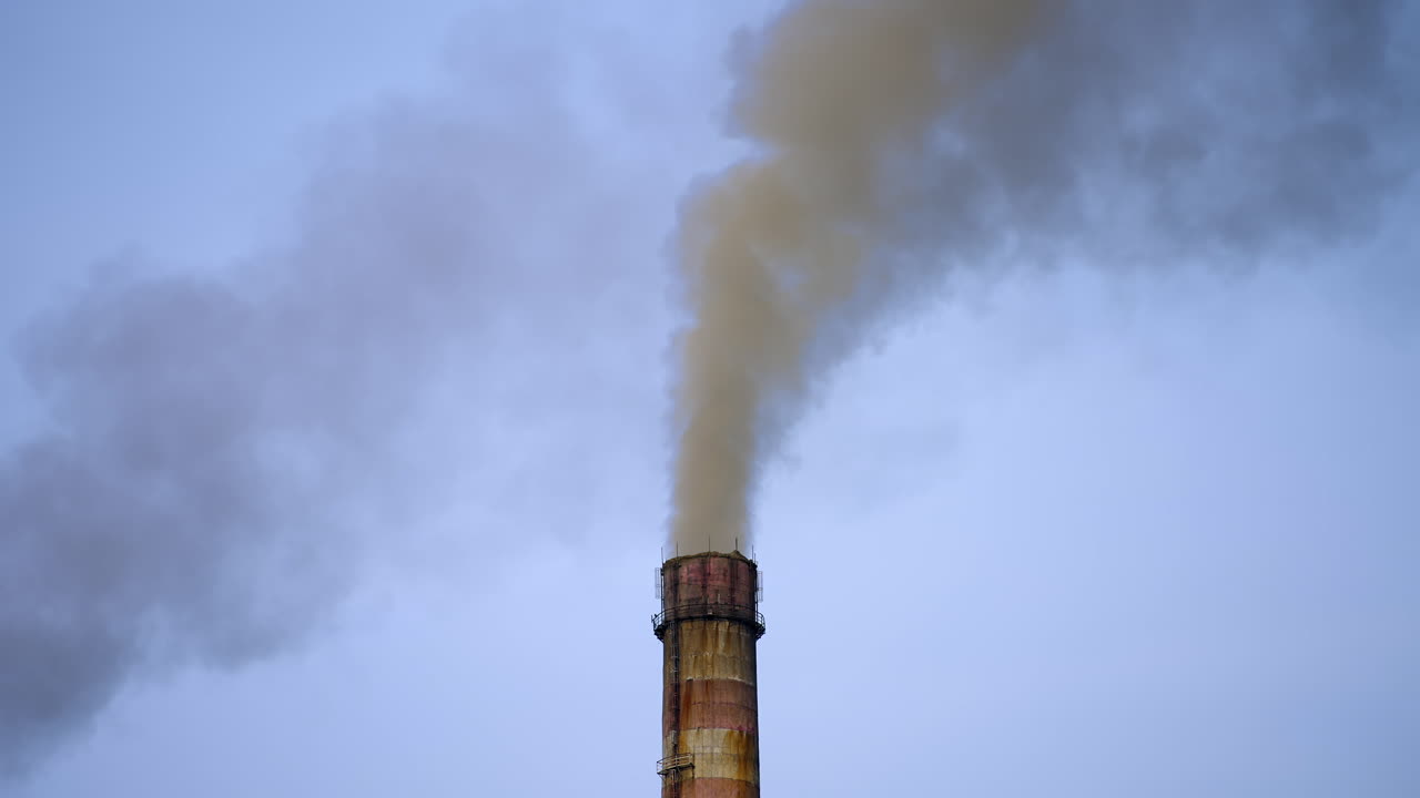 Industrial high pipe with smoke. Pollution of air with dust. Smoking pipe closeup video from a drone.
