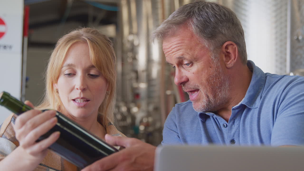 Workers With Laptop Meeting Checking Production Inside Winery With Storage Tanks