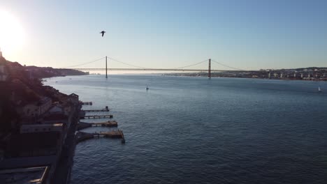 drone shot starting a with a beautiful sunset shot and transitioning into a panoramic view of lisbon and the river tejo in portugal.