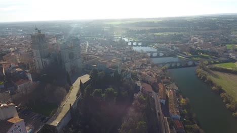 amazing aerial drone view of beziers cathedral with river orb and train crossing