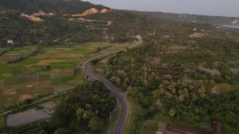 Vista-Aérea,-Camino-Sinuoso-Entre-Colinas-Y-Costa-Del-Mar