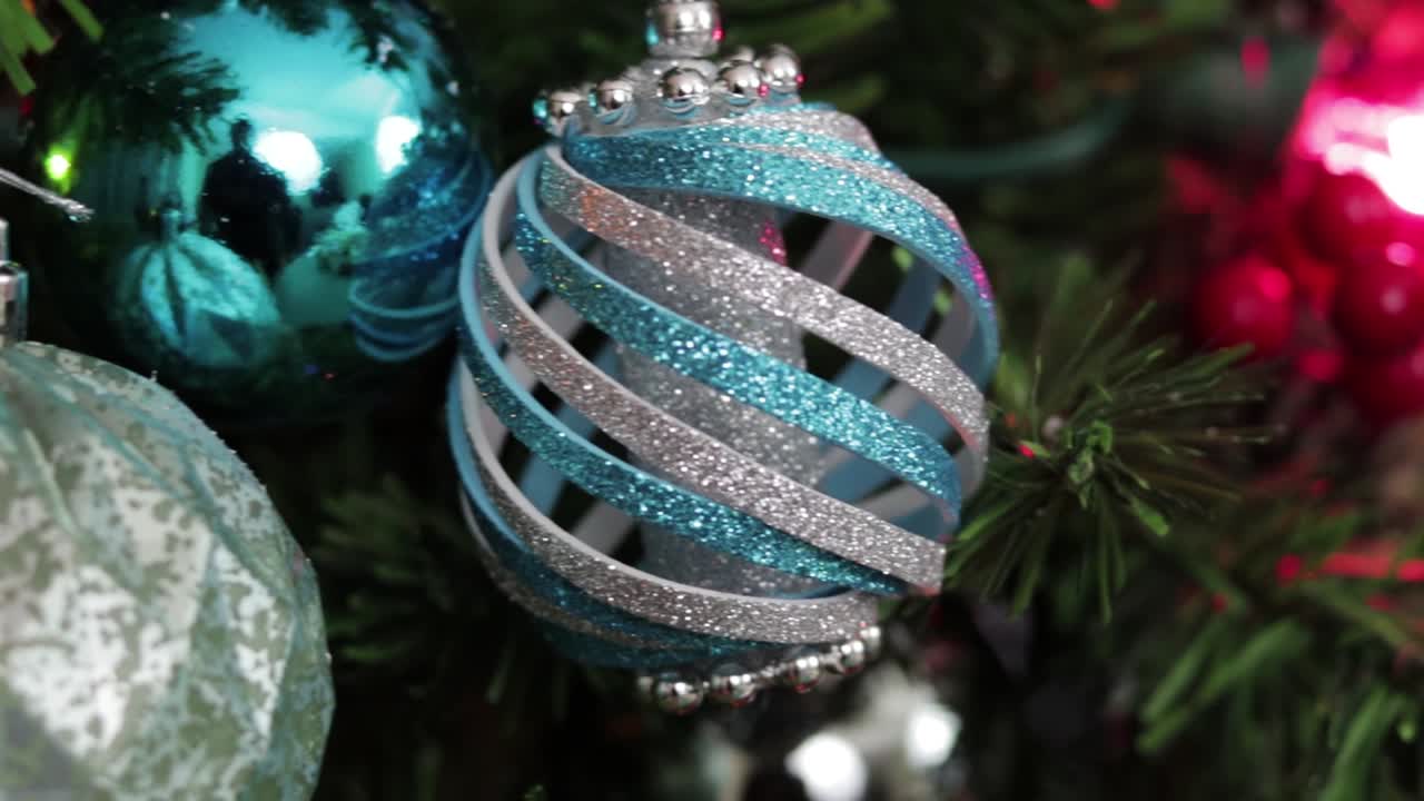 adornos navideños azules, colgando del árbol