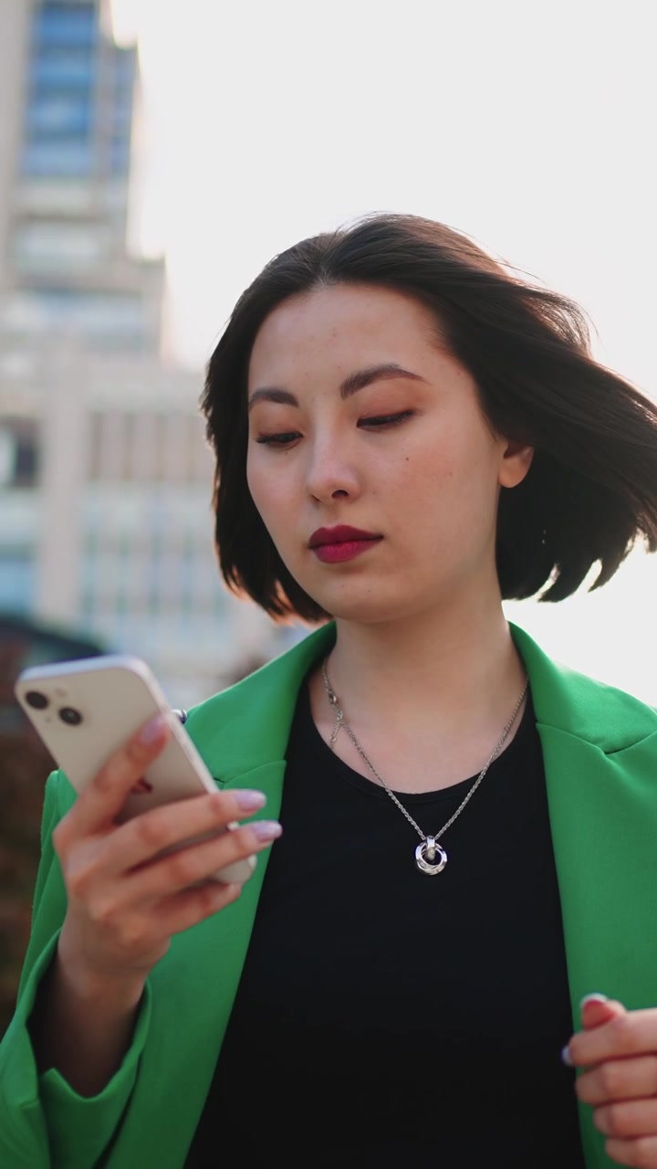 Giovane donna che usa lo smartphone all'aperto in un ambiente urbano