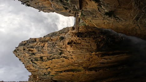 4k vertical shot of the old bridge and mountain mine at royal trail in gorge chorro, malaga province, spain