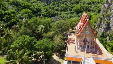 aerial sliding footage towards the right revealing coconut trees and the this buddhist temple