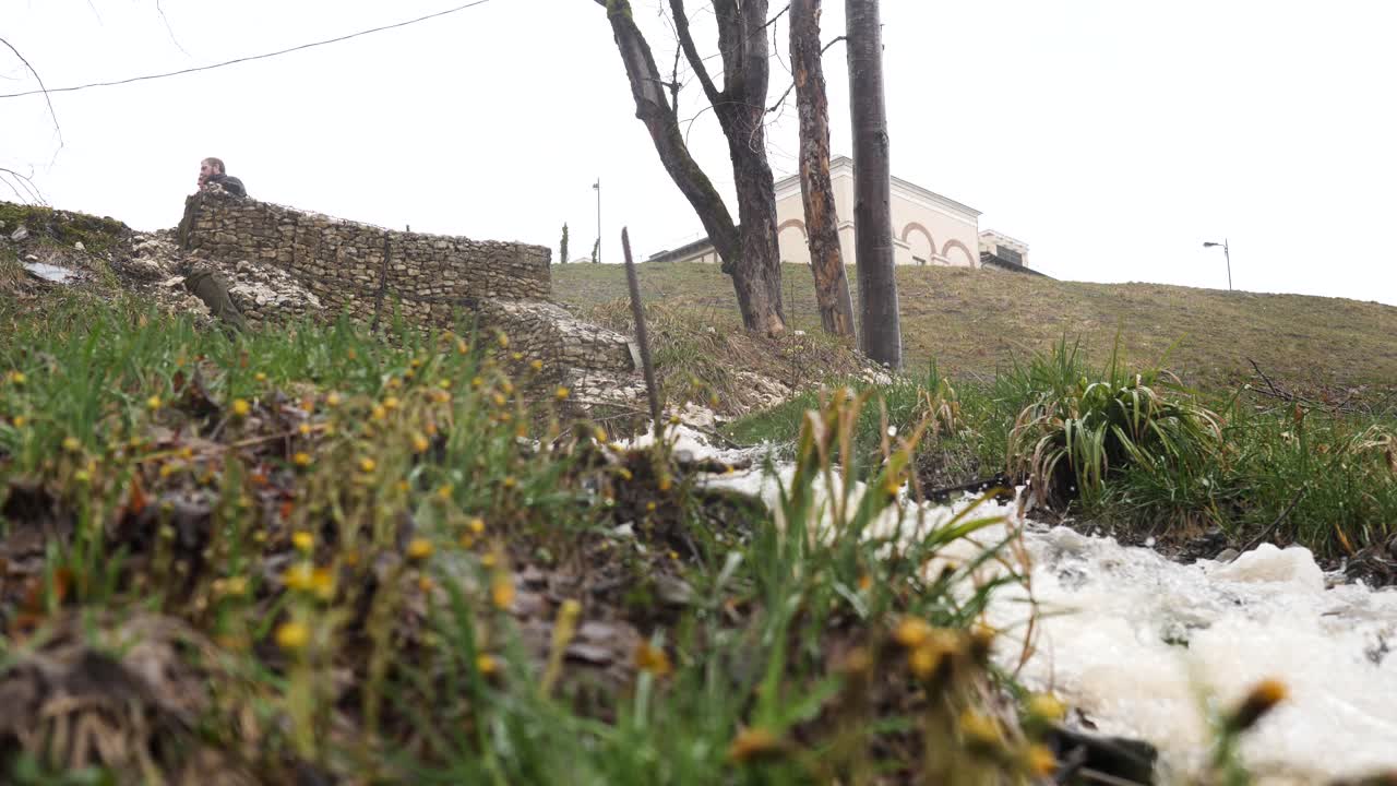돌 벽 에 앉아 있는 사람 과 함께 공원 을 가로질러 흐르는 하천