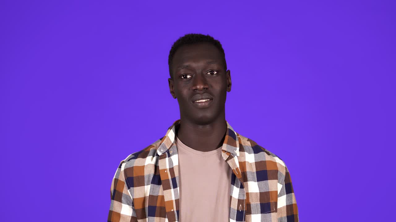 Afro american man over isolated over blue background looking at the camera blowing a kiss with hand on air being lovely and happy. Love expression