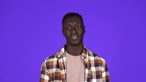 afro american man over isolated over blue background looking at the camera blowing a kiss with hand on air being lovely and happy. love expression