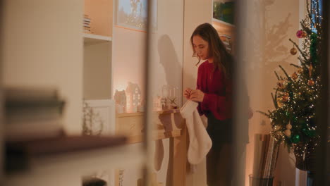 mujer colgando medias de navidad en la mesa