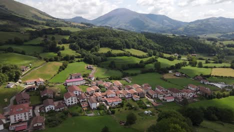 Panning-left-top-view-shot-of-village-Amaiur-,-a-small-village-in-the-mountains-with-white-houses-and-red-rooftops