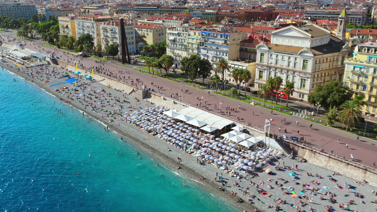 Aerial drone view of Nice Old Town with colorful buildings, terracotta rooftops, and busy beachfront