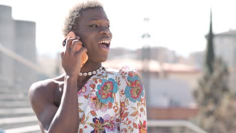 transgender woman talking on the phone standing outdoors.