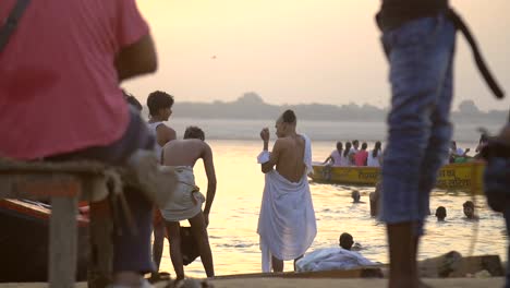 man wraps himself in white sheet by the ganges