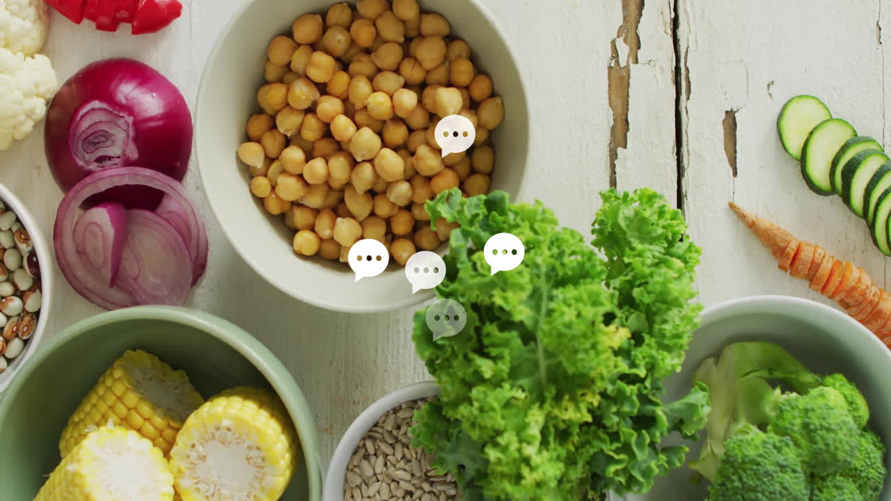 Fresh vegetables and chickpeas with chat bubble animation over white wooden table