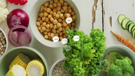 fresh vegetables and chickpeas with chat bubble animation over white wooden table