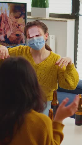 vertical video: funny friends with sticky notes on foreheads enjoying name game