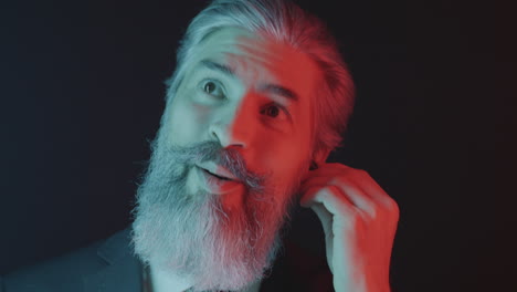a man in a suit with a beard reacts with an excited expression