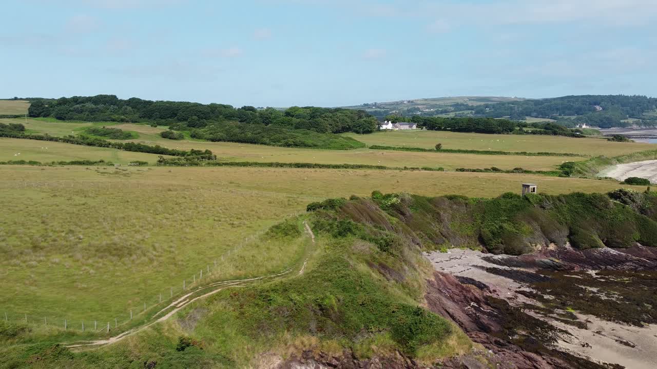 la línea costera erosionada establece una vista aérea sobre la pintoresca línea costera verde y ondulada de gales.