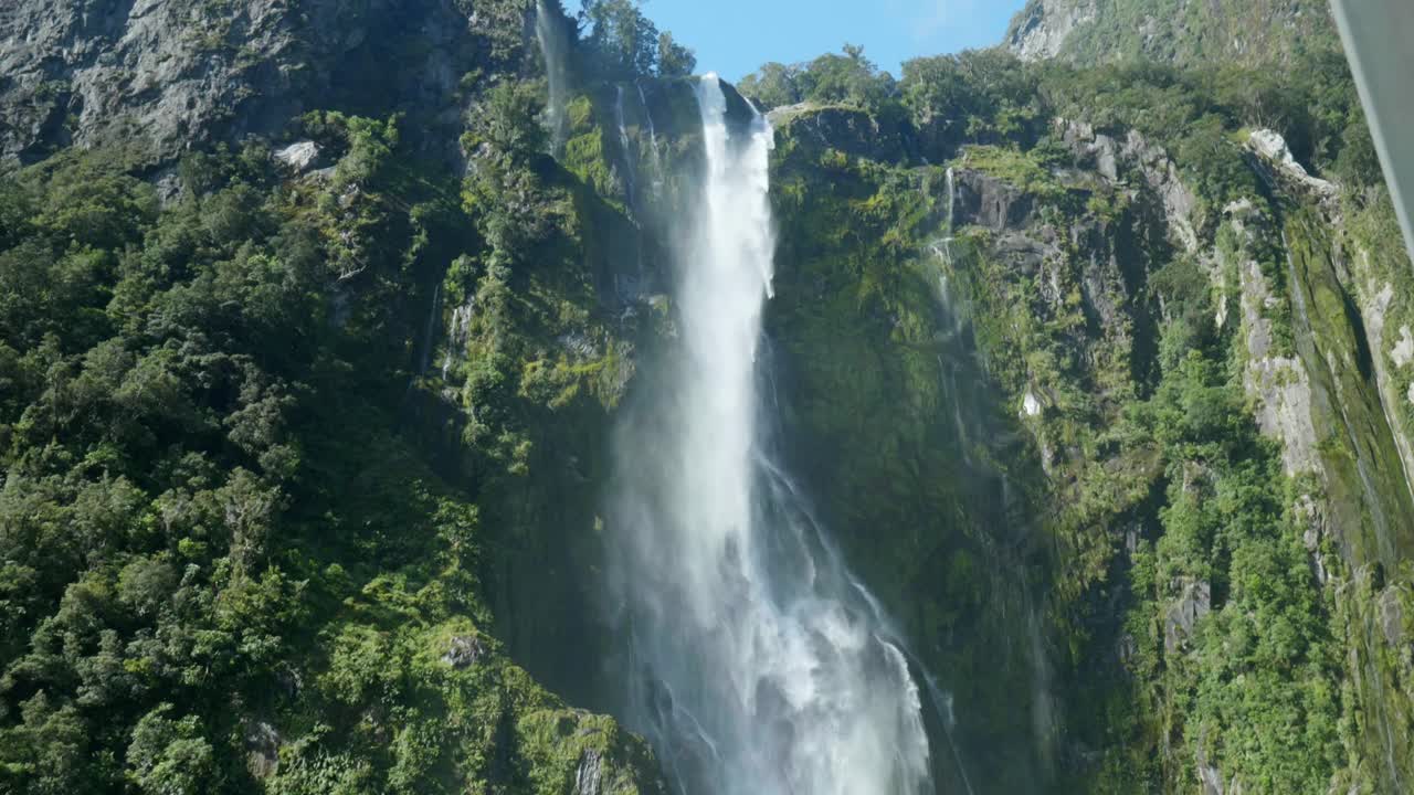 Nature's cascade: Moving down waterfall at Milford Sound in captivating stock footage