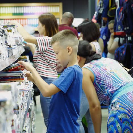 vinnitsa, ukraine - august, 2018: boy choosing buying stationery in store preparing for first day in school.