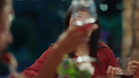 amigos celebrando en una fiesta de cena haciendo brindis bebiendo vino disfrutando de una feliz reunión charlando compartiendo comida divirtiéndose por la noche sentados a la mesa al aire libre 4k