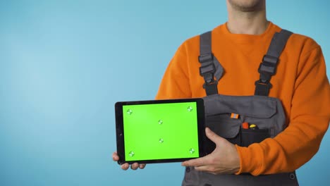 una toma cercana de las manos del reparador sosteniendo una tableta con pantalla verde