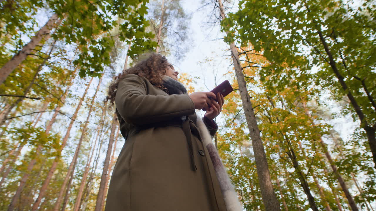 Woman in forest using smartphone