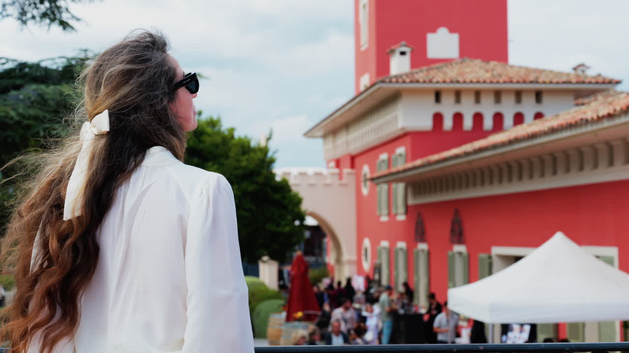 Woman with long hair, dressed in white, posing at the Cremat Castle Winery
