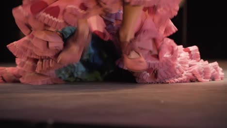 bailaora de flamenco tacones duros y mueve la cola del vestido rosa con lunares rojos