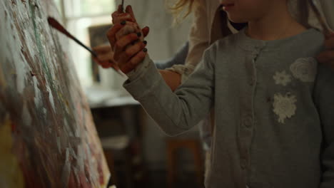 happy children spending time with mother on painting workshop in art studio.